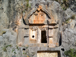 High angle drone aerial view of ancient greek rock cut tombs carved into cliffside in Myra (Demre, Turkey)