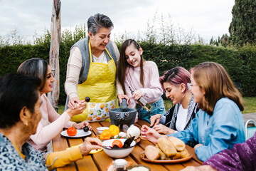 latin grandmother and granddaughter, daughter cooking mexican food at home, three generations of women in Mexico