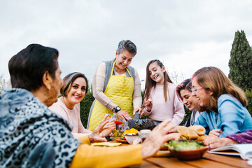 latin grandmother and granddaughter, daughter cooking mexican food at home, three generations of women in Mexico