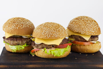 Group of burgers on a wooden board on a light background