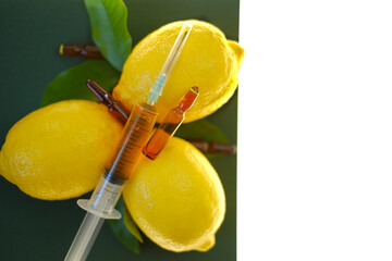 Vitamin C. Serum with Vitamin C. Glass ampoules , syringe with injection solution and lemons fruits...
