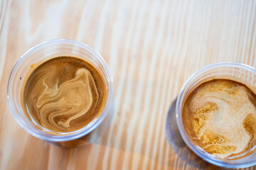 Two cup of dirty coffee on wooden table background.