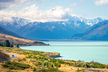 A camper van is driving along Lake Lake Pukaki in Mount Cook National Park, New Zealand.
