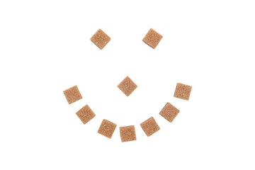 Smile made from cane sugar cubes on a white background.