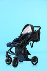 Modern baby stroller on color background