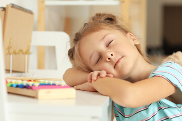 Cute little girl sleeping at table