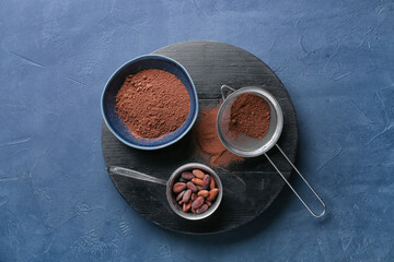Bowls with cacao powder and beans on dark background