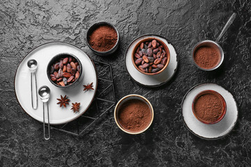 Obraz na płótnie Canvas Bowls with cacao powder and beans on dark background