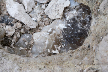 Mineral inside of stone. Unpolished quartz excavating or deposit. Semi-precious gems mining in limestone