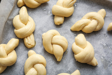 Baking sheet with uncooked garlic buns, closeup