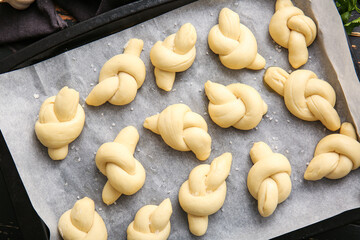 Baking sheet with uncooked garlic buns, closeup