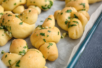 Baking dish with tasty garlic buns, closeup