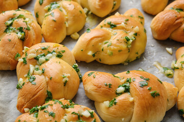 Baking sheet with tasty garlic buns, closeup