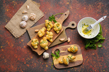 Fototapeta premium Boards with tasty garlic buns on grunge background
