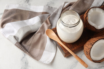 Jar of tasty coconut yogurt on light background