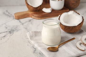 Jar of tasty coconut yogurt on light background