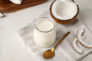 Jar of tasty coconut yogurt on light background