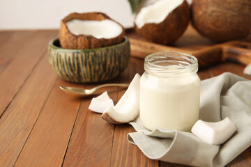 Jar of tasty coconut yogurt on wooden background
