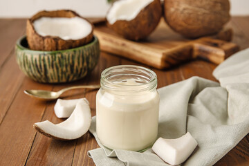 Jar of tasty coconut yogurt on wooden background