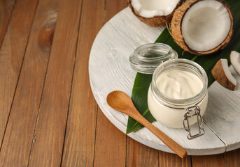 Obraz na płótnie Canvas Jar of tasty coconut yogurt on wooden background