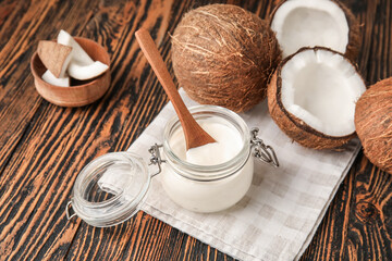 Jar of tasty coconut yogurt on wooden background