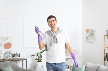 Young man with air freshener at home