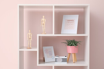 Stylish decor on rack near color wall