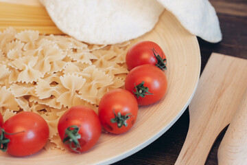 italian pasta on a wooden table cherry tomatoes cooking