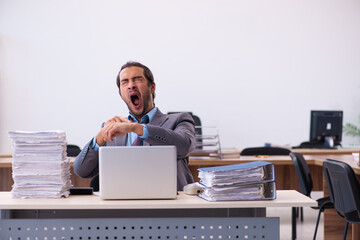 Young male employee unhappy with excessive work in the office
