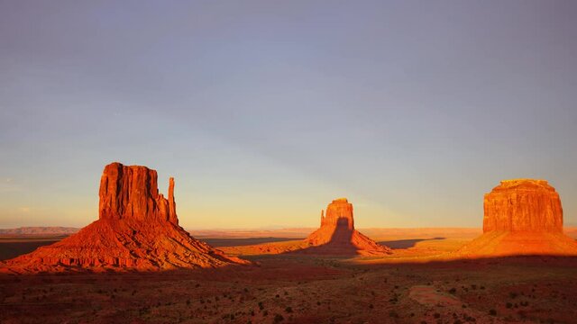 Time Lapse of beautiful clouds behind the rock formations of Monument Valley as the sun sets.
