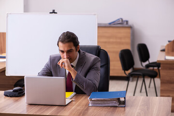 Young male business trainer in the office during pandemic