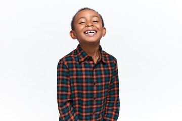 Cute African child expressing excitement, looking at camera with broad radiant smile. Studio image of handsome joyful black little boy enjoying carefree childhood, having fun, smiling © Anatoliy Karlyuk