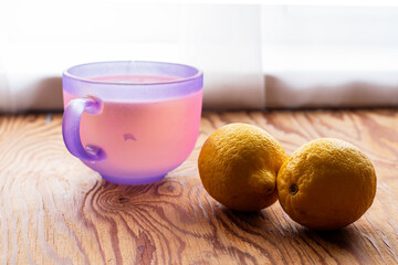 a mug of tea and two lemons on a wooden table