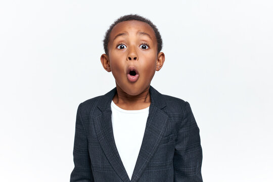Emotional scared black little boy gasping and raising eyebrows seeing something scary. Emotional African child expressing shock, astonishment or fear, being speechless because of stupefaction