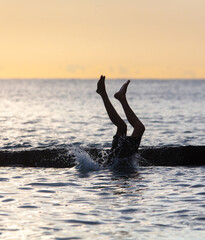 Fototapeta premium Boy swims in the sea with splashes