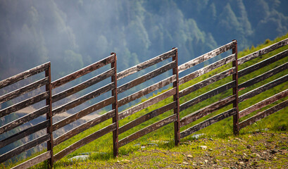 Fototapeta na wymiar Wooden fence on the side of the mountain.
