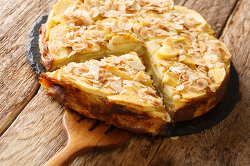 Delicious invisible apple pie with almond petals close-up on a slate board on the table. horizontal