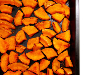 Pieces of pumpkin baked on a baking sheet