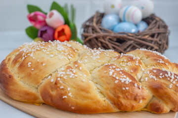 Sweet home made braided yeast bun for easter on a table