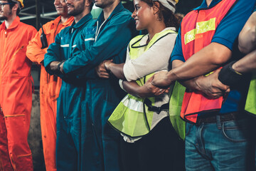 Skillful worker stand together showing teamwork in the factory . Industrial people and manufacturing labor concept . - obrazy, fototapety, plakaty