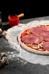 Prepared dough base for cooking pizza with ham and cheese