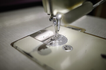Shallow depth of field (selective focus) image with an electric sewing machine in a textile factory.