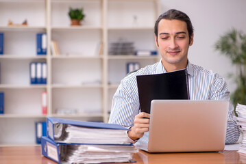 Young male employee unhappy with excessive work in the office