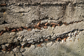stone with cartridges and casings, cement wall with casings, fragment of a monument dedicated to the war, rusty casings concreted in the wall