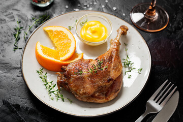 Duck leg confit served with potato chips and mustard sauce .Traditional french cuisine.