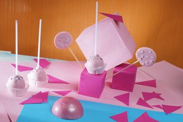 Paper colorful background and paper cubes, pink cake pops chocolate desserts