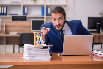 Fototapeta premium Young businessman employee in time management concept