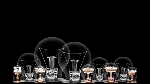 Group of light bulbs in a row going from dark to light with Digital Advertising, Content, Strategy, SEO and Media fiber text on black background. High quality 4k video.