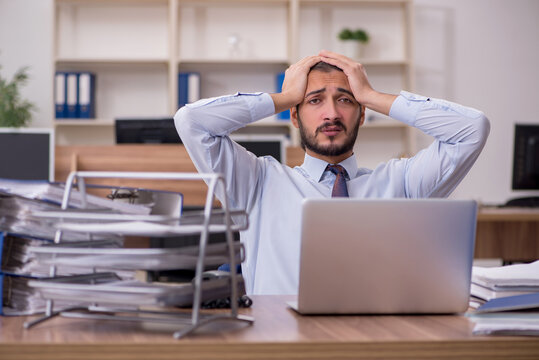 Young businessman employee unhappy with excessive work in the of