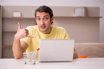 Young man in e-commerce concept at home